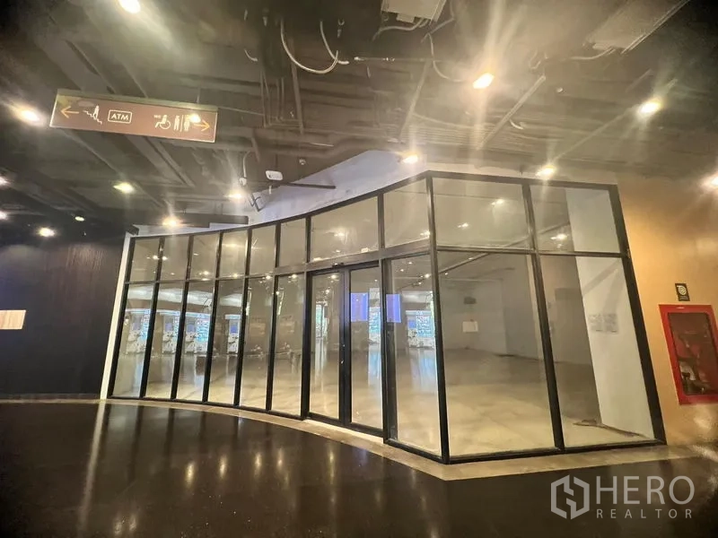 พื้นที่ขายปลีก ให้เช่าในWatthana, Bangkok - หน้าร้านกระจกโค้งติดทางเดินในศูนย์การค้า เพดานเปิดโล่งพร้อมแสงสว่างทั่วถึง.