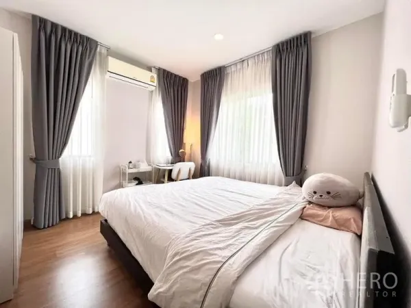 บ้าน ให้เช่าหรือขายในBang Khen, Bangkok - ห้องนอนมุมบ้าน ชุดเครื่องนอนสีขาว โต๊ะทำงาน เครื่องปรับอากาศ และหน้าต่างสองด้าน