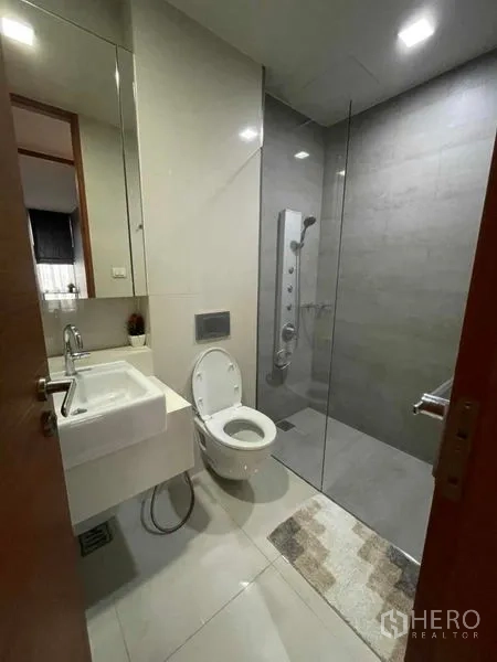 公寓 出租在Watthana, Bangkok - 现代卫浴，玻璃淋浴间、挂墙马桶与洗手台。