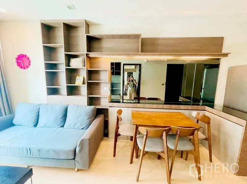 Condominium for rent - Living area with sofa, dining set, and mirrored wall storage.