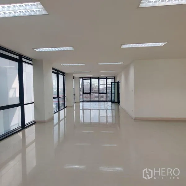 Office Space for rent in Bang Kho Laem, Bangkok - Open office with wraparound glass and doorway to a balcony or foyer.