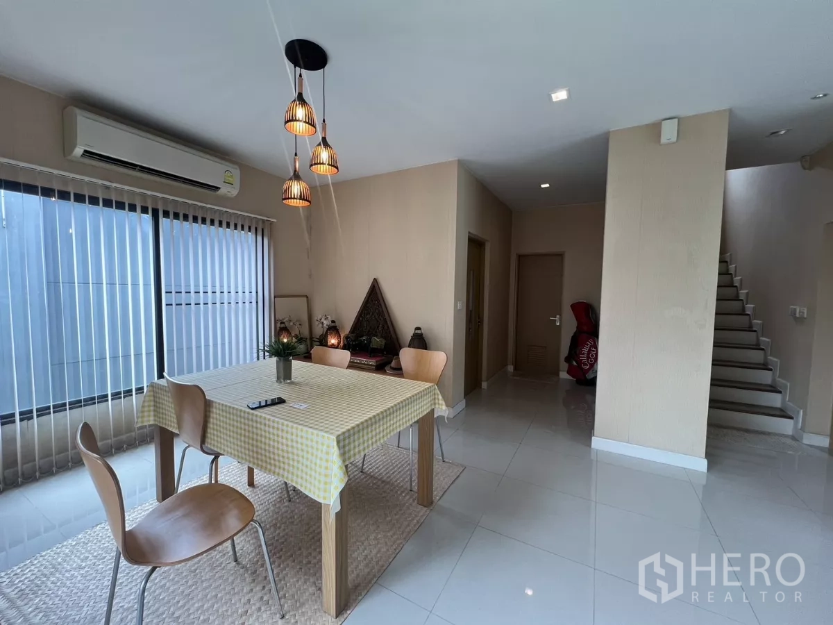 Detached House for rent in Bang Kapi, Bangkok - Minimalist dining table with checked tablecloth next to stairs and windows.