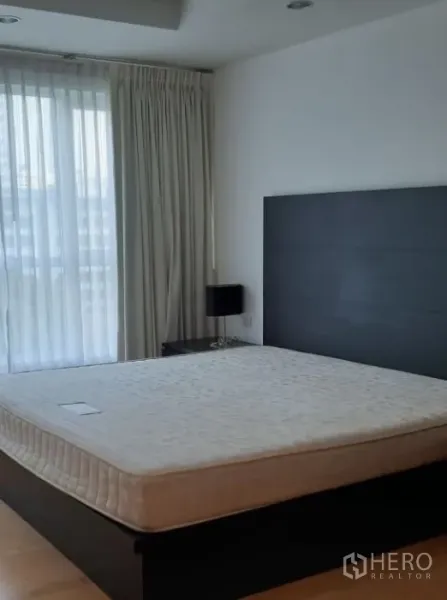 Condominium for rent in Watthana, Bangkok - Bright master bedroom with king bed, floor-to-ceiling curtains and abundant natural light.