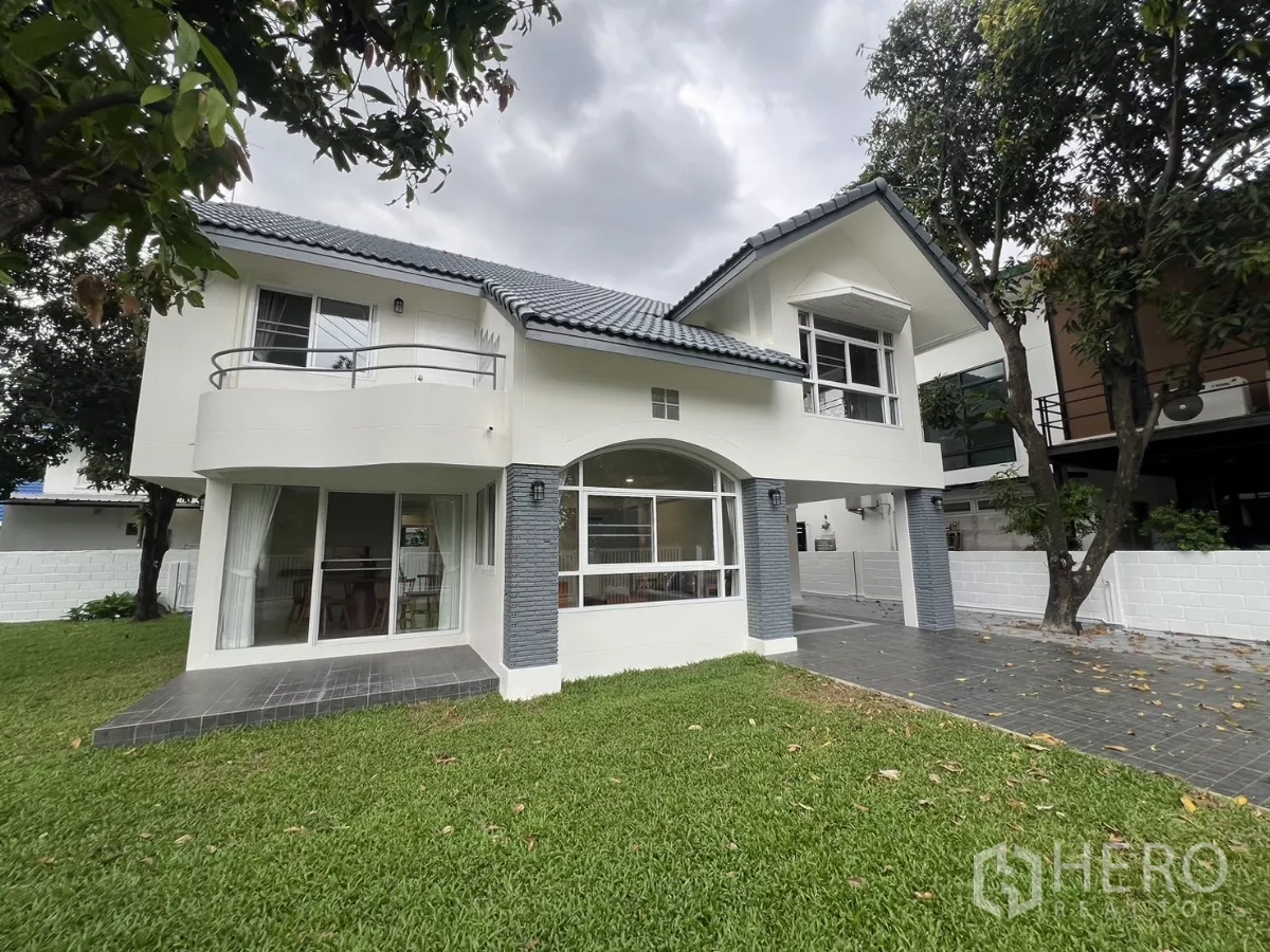 Detached House for rent in Saphan Sung, Bangkok - Front elevation showing curved balcony, arched window and wide green garden.
