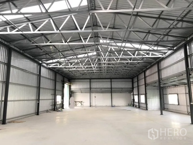Warehouse for rent in Nonthaburi - Open-plan warehouse space with clear-span steel frame, side windows and ventilation louvers.