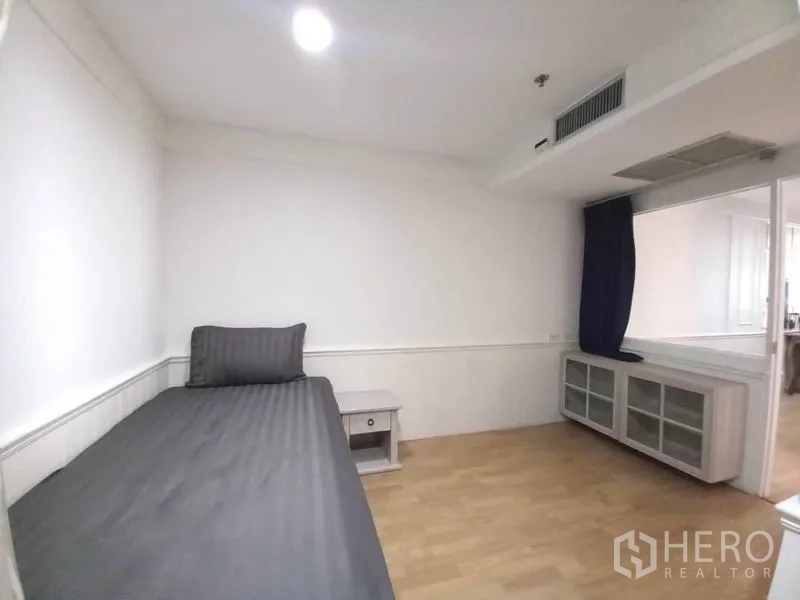 公寓 出租在Khlong Toei, Bangkok - 客卧配单人床、床头柜与窗下储物柜。