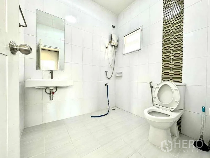 บ้าน ให้เช่าในLat Krabang, Bangkok - ห้องน้ำปูกระเบื้องสีขาวสะอาด พร้อมฝักบัวเครื่องทำน้ำอุ่น โถสุขภัณฑ์ อ่างล้างหน้า และช่องหน้าต่าง