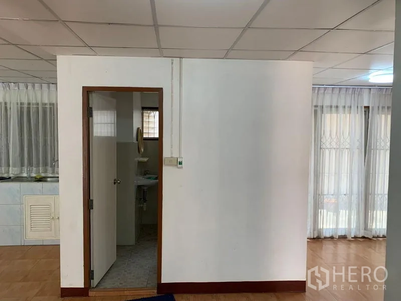 办公空间 出租在Chatuchak, Bangkok - 隔墙与通往卫生间的门，旁为开放式办公区。