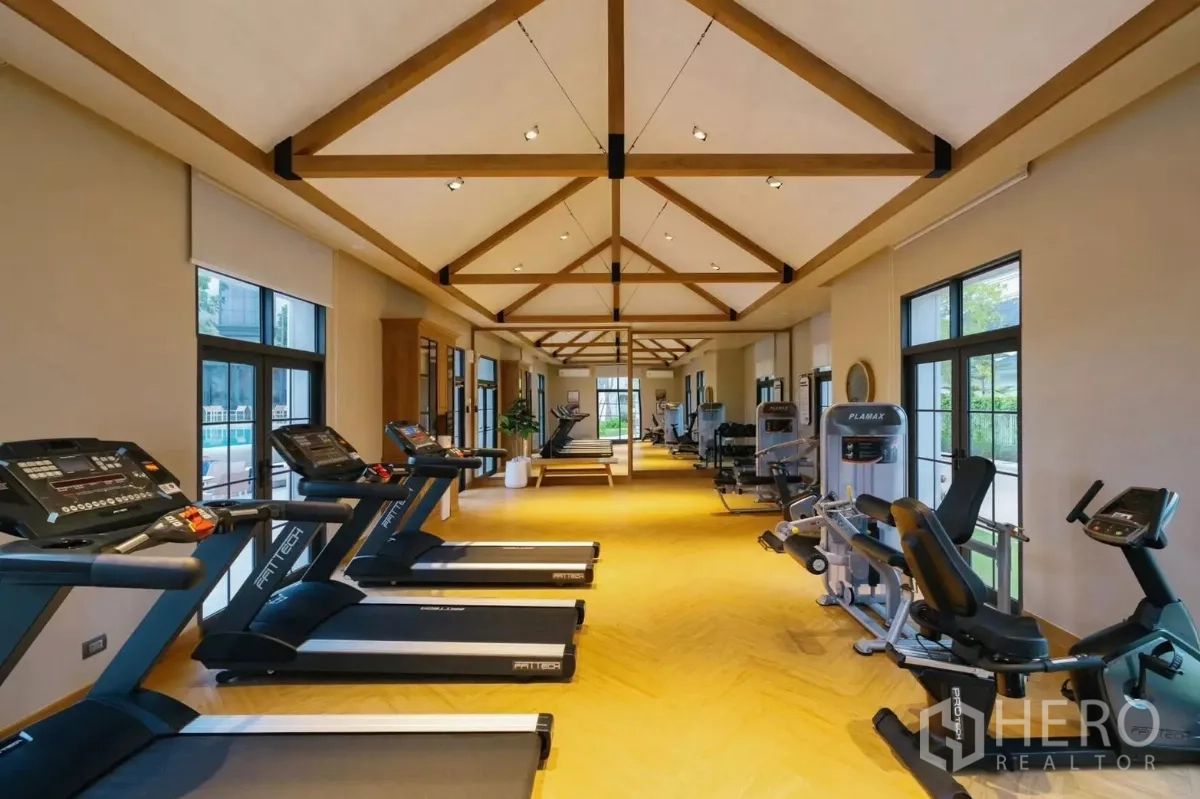Detached House for rent in Bang Phli, Samut Prakan - Fitness center with treadmills, weight machines and vaulted ceiling beams.