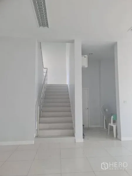 โรงงาน ให้เช่าหรือขายในLam Luk Ka, Pathum Thani - โถงชั้นล่างสว่าง พื้นกระเบื้องสีขาว พร้อมบันไดทางขึ้นกลางอาคาร