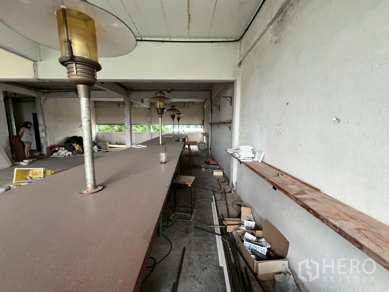 零售空间 出租在Watthana, Bangkok - 长吧台与墙面搁板，箱件与线路展示现有管线。