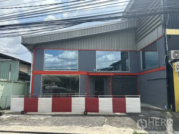 Warehouse for rent in Suan Luang, Bangkok - Street-facing two-storey warehouse facade with grey cladding, red trim and large glass windows in Suan Luang.