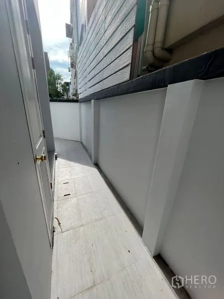 สำนักงานที่บ้าน ให้เช่าหรือขายในWatthana, Bangkok - ทางเดินด้านข้างแคบ ผนังสีขาวและพื้นกระเบื้องข้างตัวบ้าน