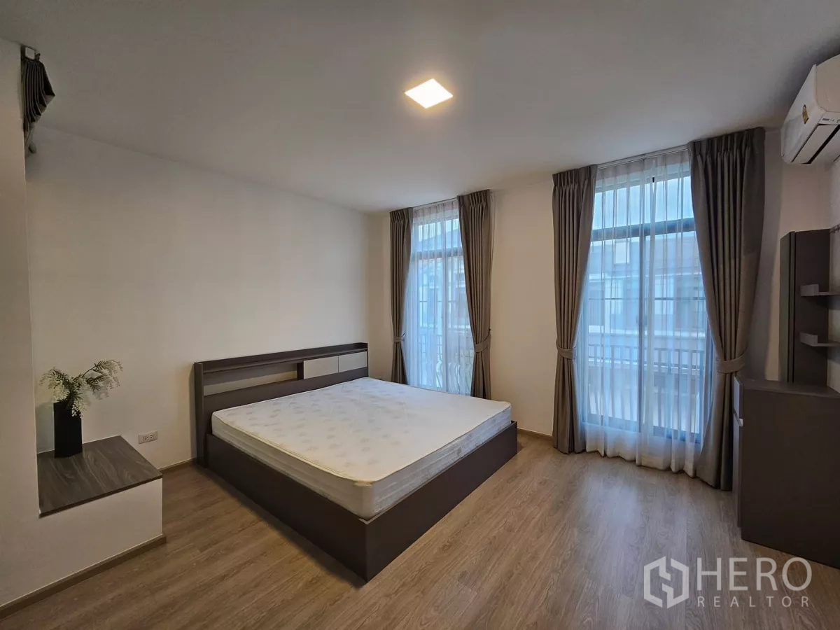 Townhouse for rent in Bang Phli, Samut Prakan - Spacious master bedroom with large windows, curtains and air conditioning