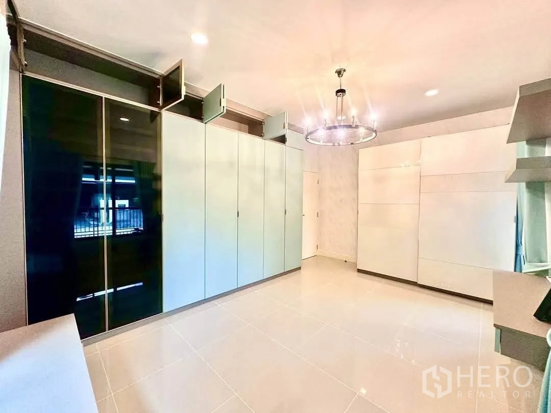 Detached House for rent in Bang Kapi, Bangkok - Spacious room with floor-to-ceiling wardrobes, chandelier and glossy tile floor.