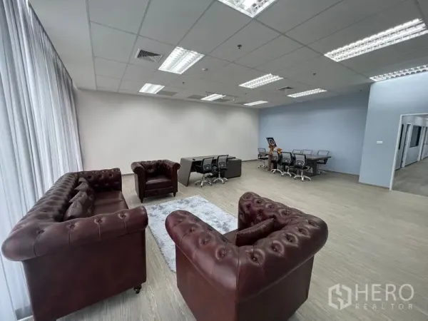 办公空间 出租 - 靠落地窗的接待区，三组切斯特菲尔德皮沙发与工作站。