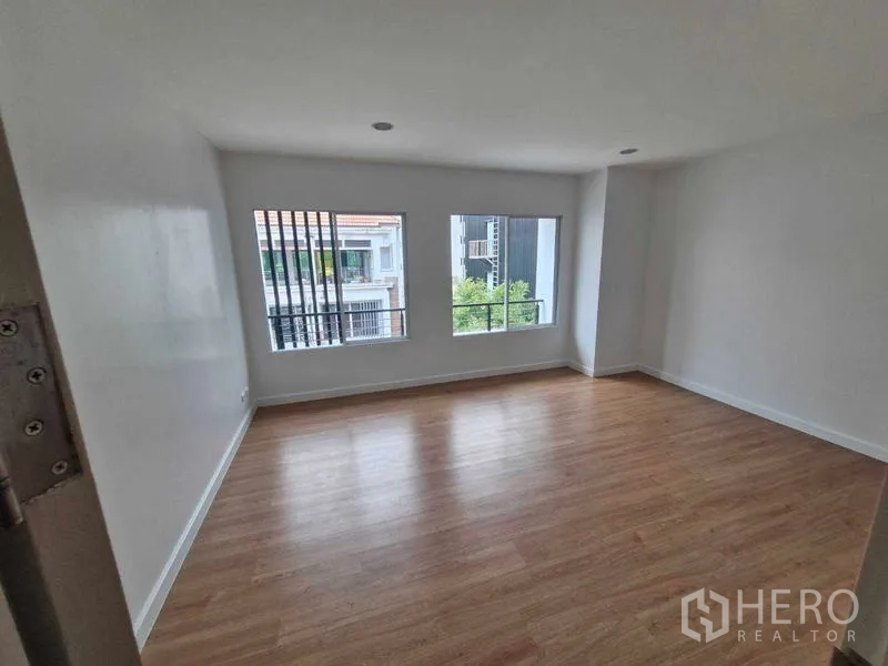 独立式住宅 出售在Rat Burana, Bangkok - 卧室设大窗，可眺望邻居与阳台栏杆