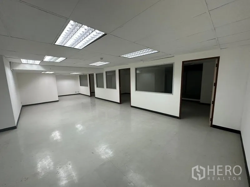 办公空间 出租在Khlong Toei, Bangkok - 开放式办公区，吊顶荧光灯，带玻璃分隔房间