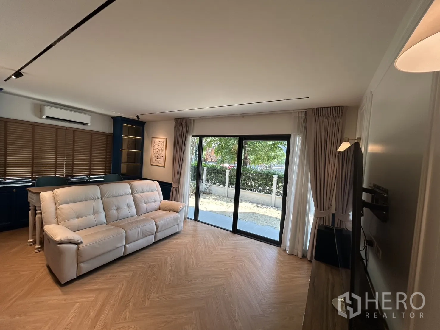 Detached House for rent in Bang Phli, Samut Prakan - Bright living room with beige sofa and sliding glass doors to the garden.