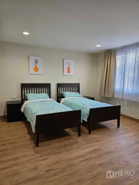 ทาวน์เฮาส์ ให้เช่าในBang Na, Bangkok - ห้องนอนที่สองมีเตียงเดี่ยวสองเตียง กรอบรูปตกแต่ง และพื้นลายไม้