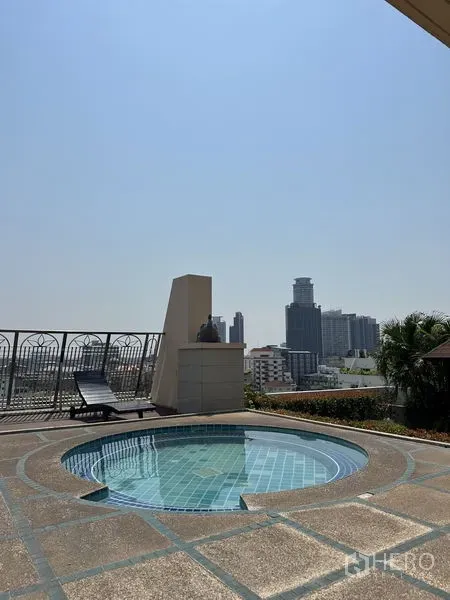 Condominium for sale in Watthana, Bangkok - Rooftop circular plunge pool with sun loungers and Bangkok skyline views at a condominium near Phra Khanong.
