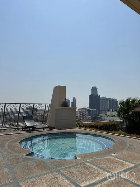 Condominium for sale in Watthana, Bangkok - Rooftop circular plunge pool with sun loungers and Bangkok skyline views at a condominium near Phra Khanong.