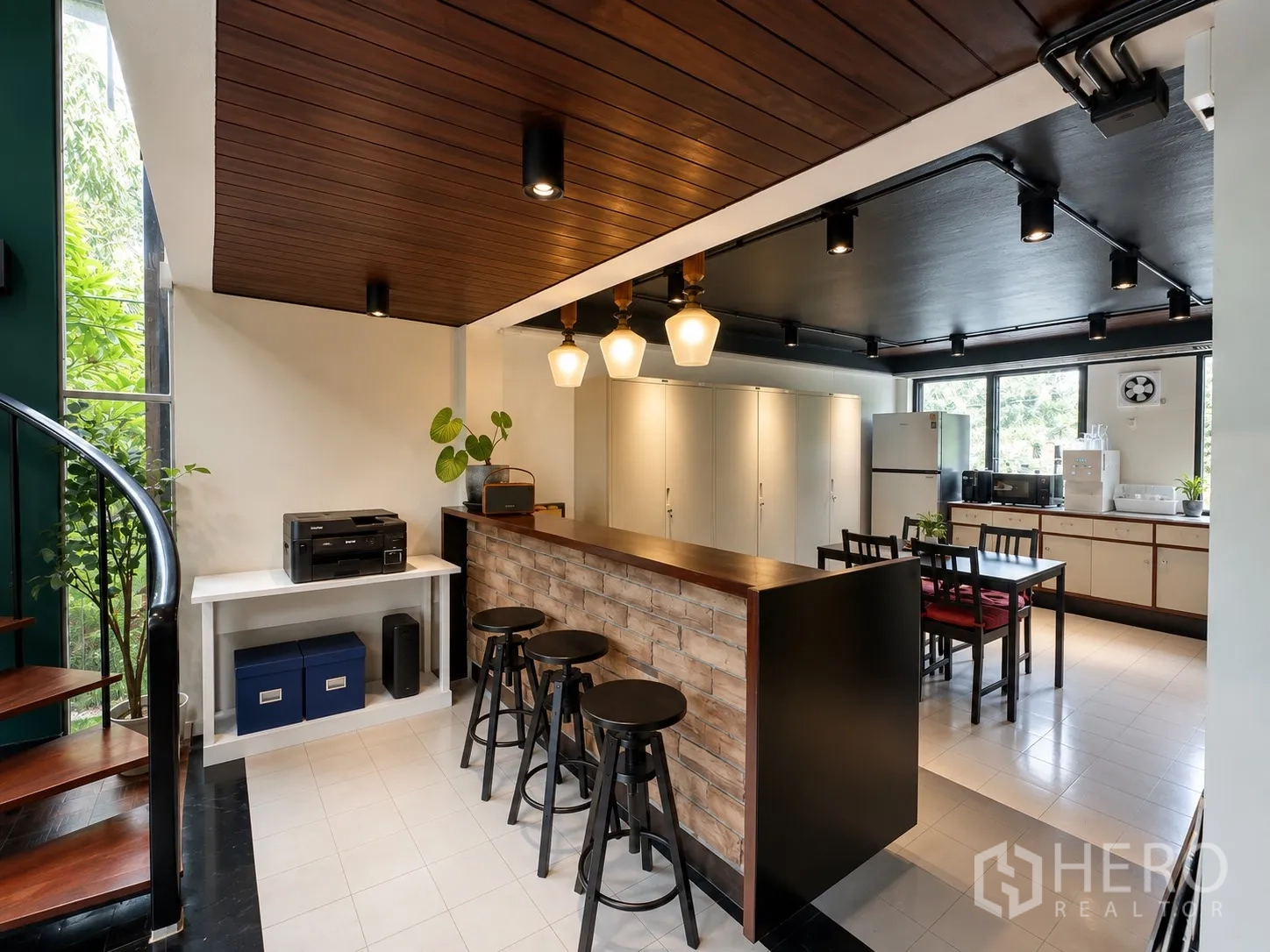 办公室 for rent in Phaya Thai, Bangkok - 茶水间配砖纹吧台、黑色吧椅、柜体与电器，旁有螺旋楼梯。