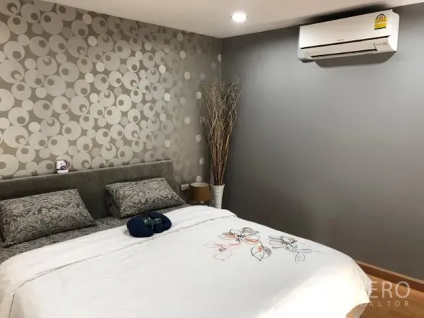 คอนโด ให้เช่าในKhlong Toei, Bangkok - ห้องนอนหลักเตียงคู่ วอลเปเปอร์ลายเด่น เครื่องปรับอากาศ และแสงไฟนุ่มนวล