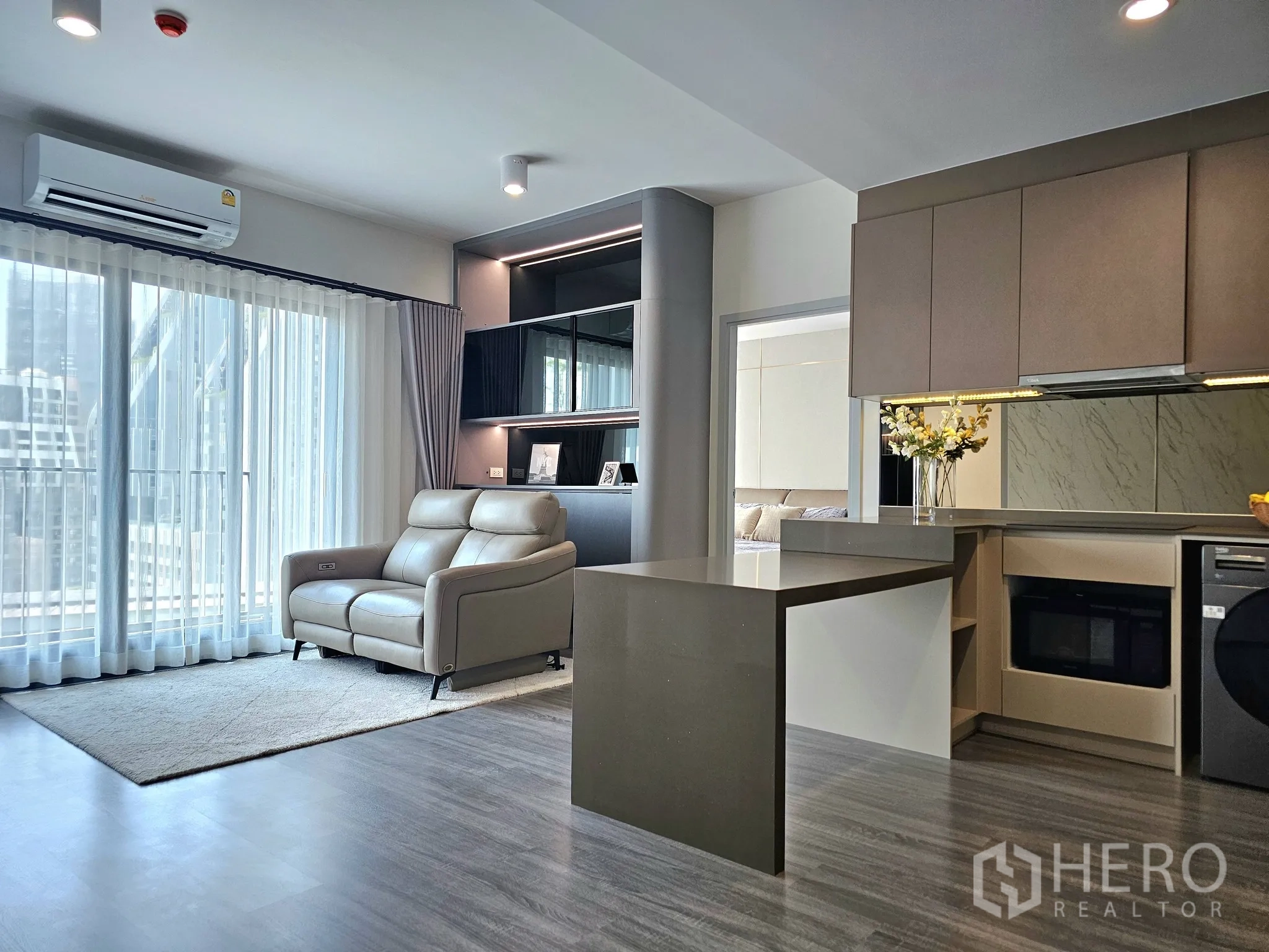 คอนโด for sale in Bang Rak, Bangkok - ห้องนั่งเล่นโปร่งแสง หน้าต่างบานใหญ่ พรมสีอ่อน และเคาน์เตอร์ครัวด้านข้าง