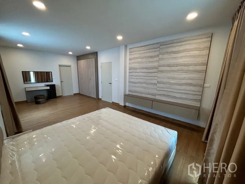 Detached House for rent in Bang Phli, Samut Prakan - Spacious master bedroom with bed, built-in wardrobes and vanity table.