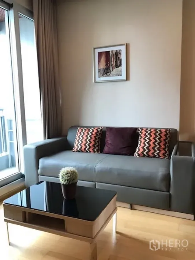 公寓 出租在Ratchathewi, Bangkok - 明亮客厅，灰色沙发、玻璃茶几与通阳台的推拉门