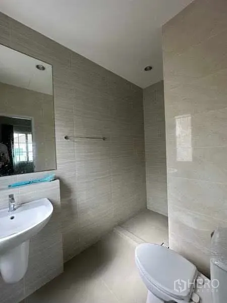 Detached House for sale in Bang Khen, Bangkok - Tiled bathroom with walk-in shower, toilet, and a mirror above the basin.