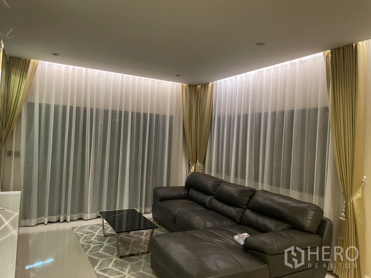 บ้าน ให้เช่าหรือขายในLam Luk Ka, Pathum Thani - มุมนั่งเล่นอบอุ่น ผ้าม่านโปร่งสูงจรดเพดาน โซฟาหนังและโต๊ะกลางหินอ่อน