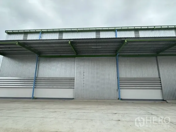 คลังสินค้า ให้เช่าในWang Noi, Phra Nakhon Si Ayutthaya - ด้านหน้าโกดังใกล้ ๆ พร้อมประตูบานเลื่อนและกันสาดลึกสำหรับขนถ่ายสินค้า