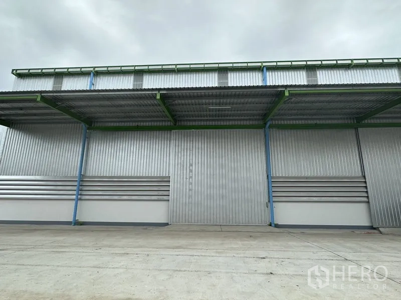 คลังสินค้า ให้เช่าในWang Noi, Phra Nakhon Si Ayutthaya - ด้านหน้าโกดังใกล้ ๆ พร้อมประตูบานเลื่อนและกันสาดลึกสำหรับขนถ่ายสินค้า