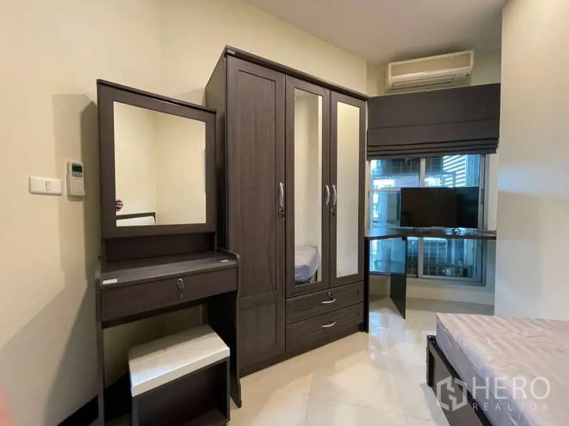 房间 出租在Khlong Toei, Bangkok - 紧凑卧室，深色木质衣柜、梳妆台、电视桌与空调