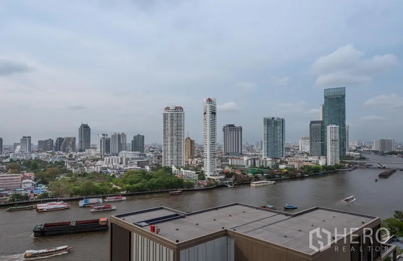 Condominium for rent in Bang Kho Laem, Bangkok - High-floor view of the Chao Phraya River with boats and Bangkok skyline towers.