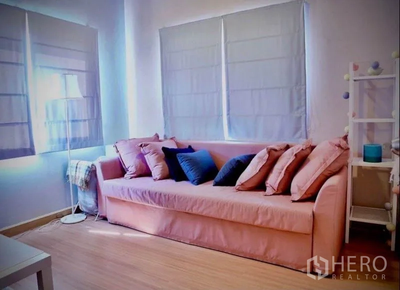 Detached House for rent or sale in Bang Phli, Samut Prakan - Guest bedroom or lounge with pink sofa, pastel cushions and soft natural light