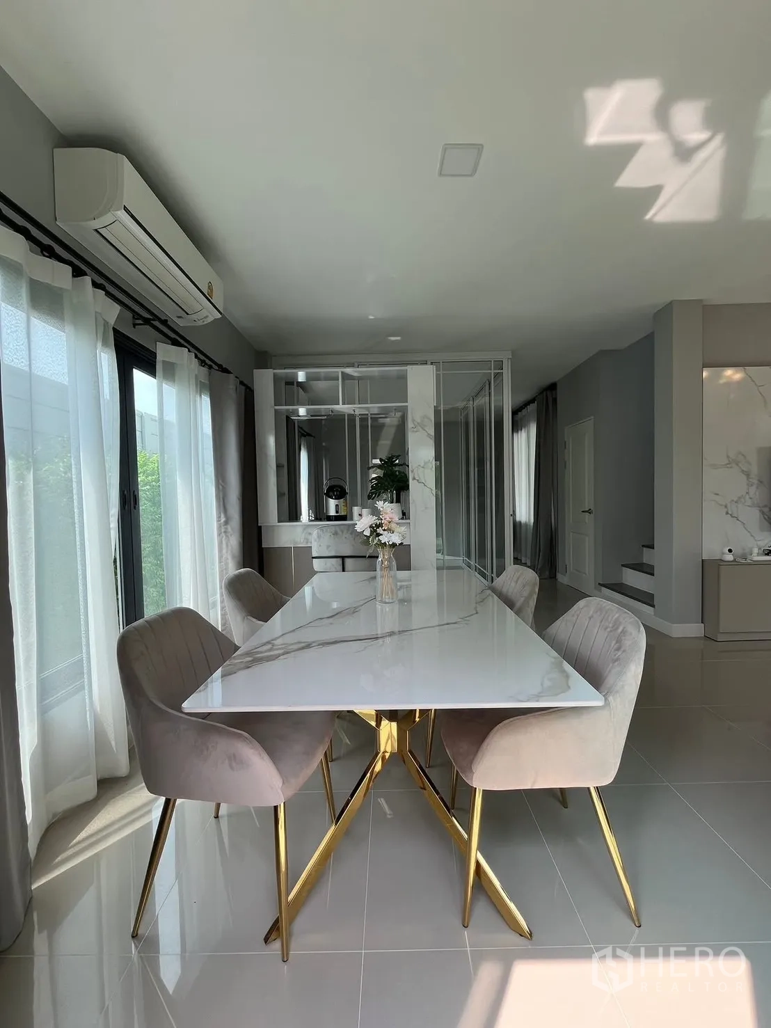 Detached House for rent in Bang Phli, Samut Prakan - Close-up of marble dining table with gold legs and soft velvet chairs near staircase.