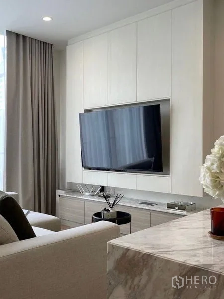 公寓 出售在Watthana, Bangkok - 现代客厅，壁挂电视、白色嵌入式柜体、石纹台面与高帘。