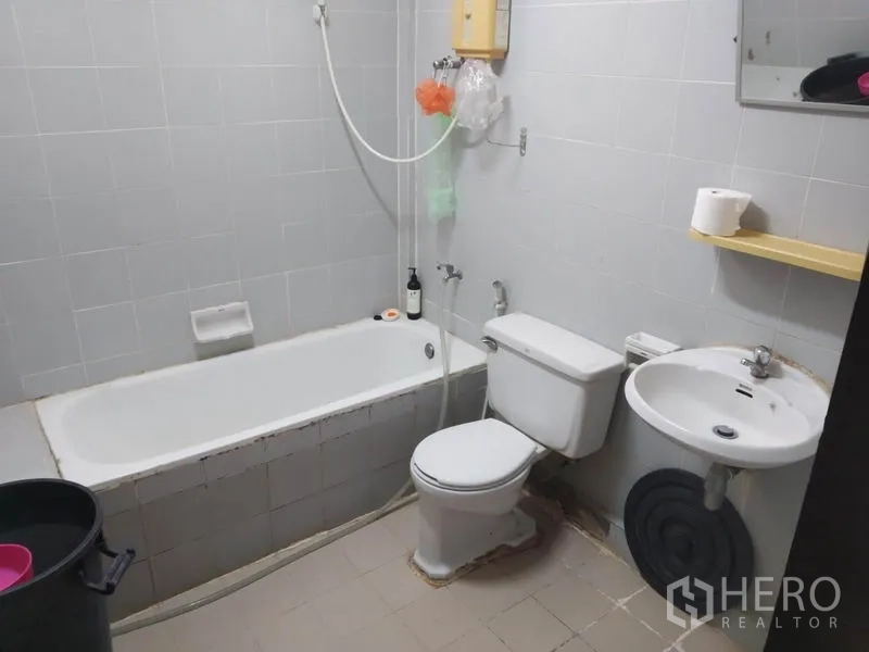 联排别墅 出租或出售在Wang Thonglang, Bangkok - 浅灰瓷砖浴室，带浴缸、坐便器、洗手盆与热水器。