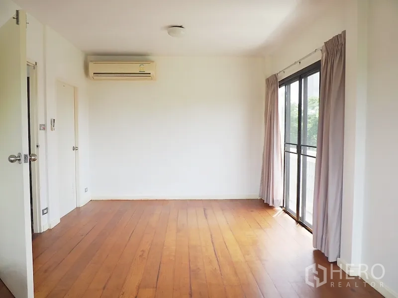 独立式住宅 出租在Chatuchak, Bangkok - 空房卧室，木地板、空调与阳台门。