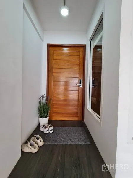 联排别墅 出租在Khlong Toei, Bangkok - 入口走廊配木门、窗户与绿植