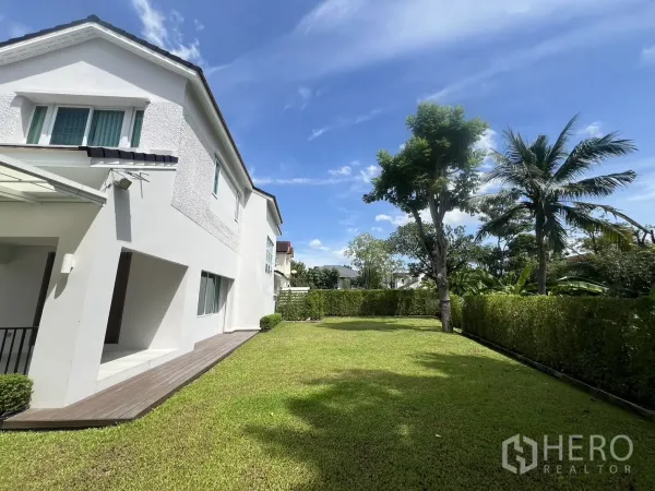 独立式住宅 出租在Mueang Samut Prakan, Samut Prakan - 侧院草坪整齐，树木与高绿篱环绕。