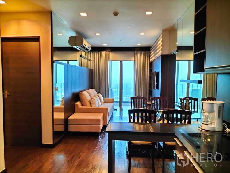 公寓 出租在Ratchathewi, Bangkok - 开放式客餐厅，沙发、餐桌及通向阳台的玻璃门。