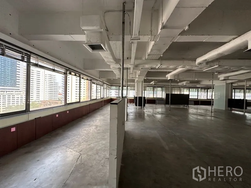 Office Space for rent in Watthana, Bangkok - Expansive open-plan office with panoramic windows, city views, and exposed industrial ceiling.