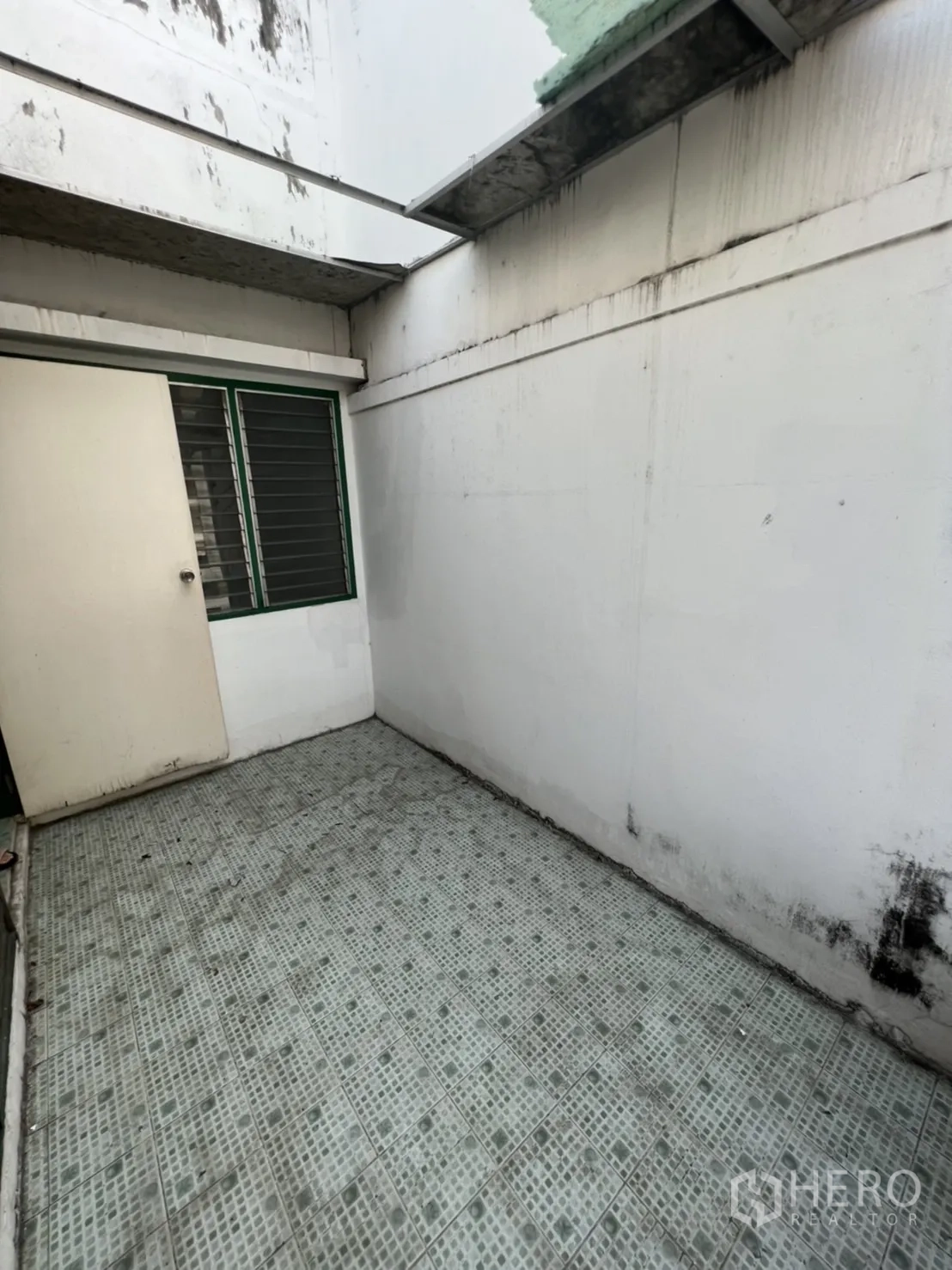 Townhouse for sale in Watthana, Bangkok - Small tiled courtyard with partial roof and drainage, suitable for laundry area.