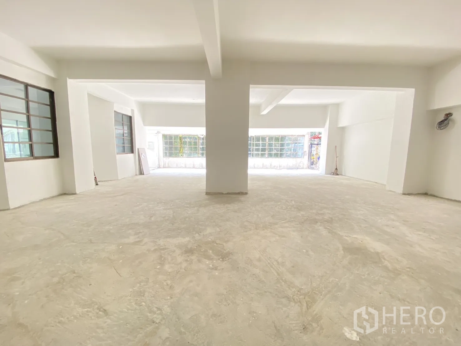 零售空间 for rent in Watthana, Bangkok - 从中央望向入口与整面窗墙，室内明亮通达。