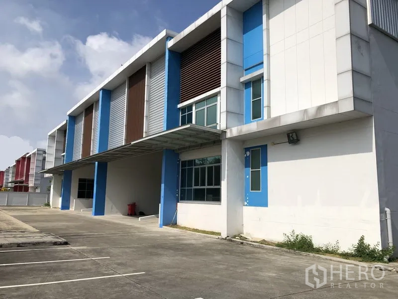 工厂 出租在Bang Sao Thong, Samut Prakan - 厂房正侧面，带雨棚的装卸区与宽敞停车位
