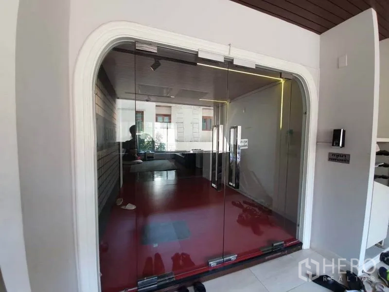 Office Space for rent in Khlong Toei, Bangkok - Glass sliding entrance doors opening to a contemporary lobby with red flooring.